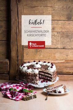 a chocolate cake with white frosting and cranberries on a table next to a fork