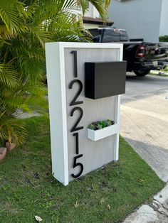 a house number sign with plants in it