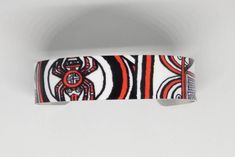 "This lightweight, adjustable aluminum cuff features artwork by Cherokee Nation artist, MaryBeth Timothy. The title of this image is \"SouthEast Spiders\". Although the art is done in a contemporary style, the designs on this cuff are actually a variety of ancient mound symbols found in or around the native burial mounds (Moundville, AL; Spiro, Ok; Etowah, GA; etc.). This cuff features the spider motif. The cuffs are easily squeezed and pulled apart to adjust to most adult sized wrists. Dimensio Adjustable Wearable Art Cuff Bracelet Gift, Symbolic White Adjustable Bracelet, White Adjustable Symbolic Bracelets, Adjustable Symbolic White Bracelet, Adjustable White Symbolic Bracelets, Artistic White Adjustable Jewelry, Unique Adjustable Hand Painted Cuff Bracelet, Hand Painted Adjustable Cuff Bracelet As Gift, Adjustable Symbolic Cuff Bracelet As Gift