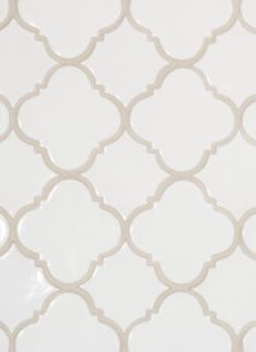 a white tile wall with an intricate pattern on it's side and the top half of