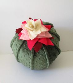 an ornament made out of fabric with a flower on it's top