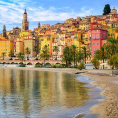 the beach is lined with colorful buildings and palm trees