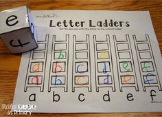 the letter ladders are next to a roll of paper with letters on it and a cube