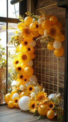 balloons and sunflowers are arranged in the shape of a letter