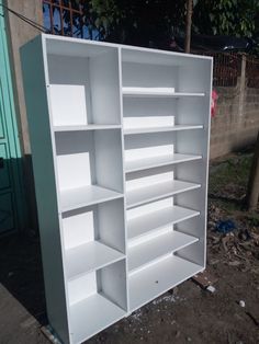 a white bookcase sitting on top of a pile of dirt