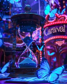 an hourglass sitting on top of a table in front of a neon sign and butterflies