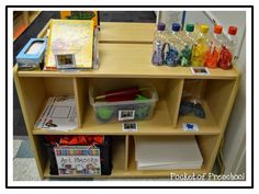 a wooden shelf filled with lots of books and crafting supplies on top of it