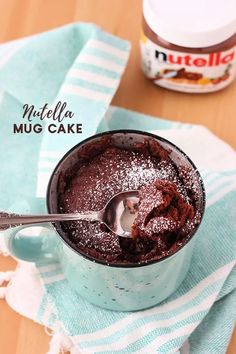 a chocolate mug cake with powdered sugar on top and a spoon in the cup