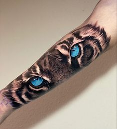 an arm with a tiger's face and blue eyes