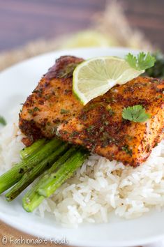 a plate with rice, asparagus and chicken on it next to a lime wedge