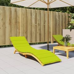 an outdoor patio with two lounge chairs and an umbrella over the sunbathing area