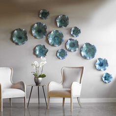 a living room with chairs and plates on the wall