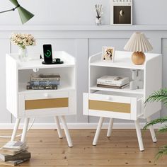 two white nightstands with gold trim on the drawers and one has a phone in it