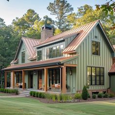 a large green house with lots of windows on the front and side of it's roof