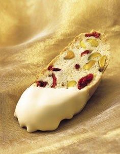 a piece of cake with white frosting and fruit toppings sitting on a gold cloth