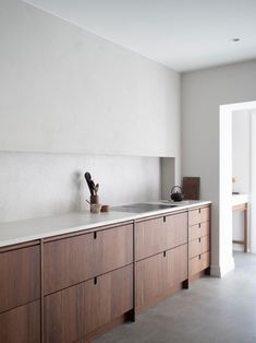 a kitchen with wooden cabinets and white walls