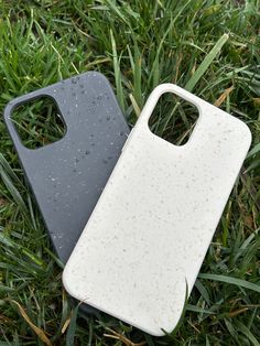 two cell phones laying in the grass next to each other