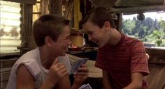 two young men are laughing and playing with each other