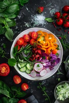 a white bowl filled with lots of different types of veggies on top of a table