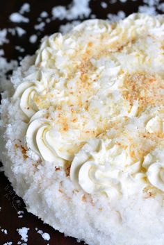 a cake with white frosting and orange sprinkles on it's top