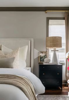 a bedroom with a bed, nightstand and window