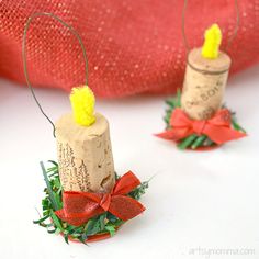 two wine corks decorated with red bows and twine, sitting on a white surface