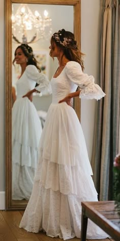 two women in dresses are looking at each other and one is wearing a dress with ruffles