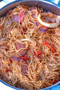 a pan filled with noodles and vegetables on top of a stove