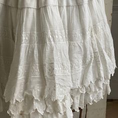 Hello and welcome to the Textile Trunk! Please follow us on Instagram, we are @textiletrunk This gorgeous textile is French and dates from the early 1900s . This petticoat ? skirt? has gorgeous lace trim and detailing throughout. This is a fairly stiff skirt, featuring layers of muslin and cotton. It buttons at the waist and has snaps to hold it closed, although one is missing (see condition details). I truly love this piece, and it could be a beautiful addition to your historic wardrobe! ~ GORG Vintage Lace Trim Petticoat For Summer, Vintage Full Skirt With Lace Trim, White Lace Ruffled Petticoat, Cotton Lace-trimmed Petticoat For Daywear, White Cotton Victorian Dress With Lace Trim, Lace Apron, Workwear Vintage, Textured Coat, Temple Dress