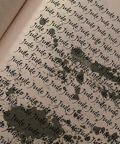 an open book with ink splatters on the pages and writing in black ink