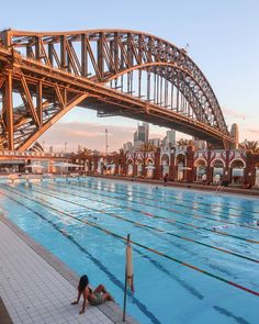 an olympic swimming pool with a bridge in the background