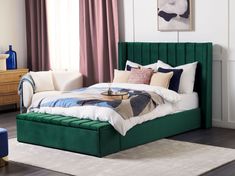 a bed with green headboard and foot board sitting in a room next to a window