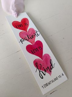 a bookmark with two hearts and the words i love is patient, not is kind on it