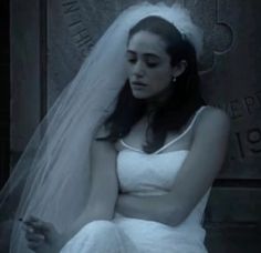 a woman in a wedding dress sitting down