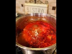 a pot filled with red liquid sitting on top of a stove