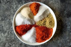 a white bowl filled with spices on top of a table