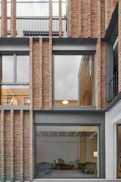 an apartment building with large windows and brick facade