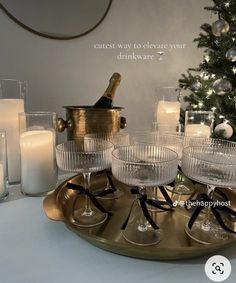 there is a tray with wine glasses and candles on it