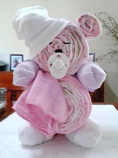 a teddy bear wrapped in pink and white towels