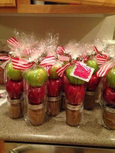 an image of homemade caramel sauce in jars with apples and candy canes on top