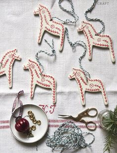 christmas ornaments are laid out on a table with scissors and other crafting supplies around them