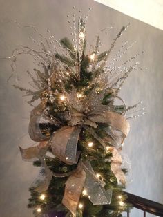 a christmas tree decorated with lights and ribbons