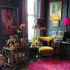 a living room filled with lots of furniture and art on the wall above it's windows