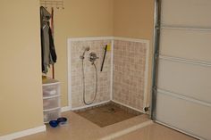 a bathroom with tiled walls and flooring next to a door that leads to a closet