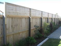 a wooden fence next to a grassy yard