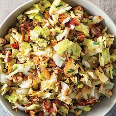 a white bowl filled with lots of food on top of a table