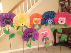 a bunch of flowers that are sitting on some sticks in front of a stair case