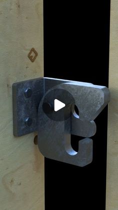 a door handle with a video playing button on it's left side and a wooden board behind it