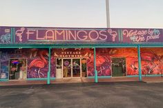 the front of a store with flamingos painted on it