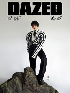 a man standing on top of a rock next to a poster with the word dazed